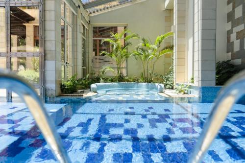 a swimming pool with blue tiles on the floor of a building at Columbia Beach Resort in Pissouri