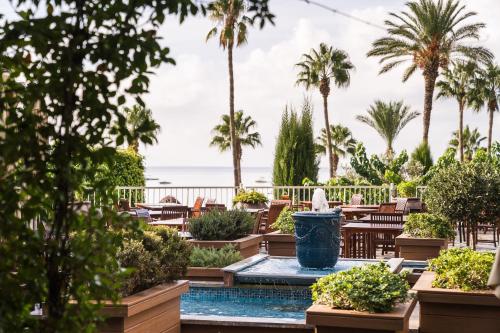 a view of a resort with a fountain and palm trees at Columbia Beach Resort in Pissouri