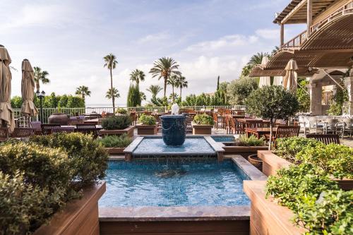 a pool with a fountain in the middle of a patio at Columbia Beach Resort in Pissouri