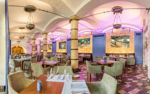 a restaurant with tables and chairs and purple ceilings at Columbia Beach Resort in Pissouri