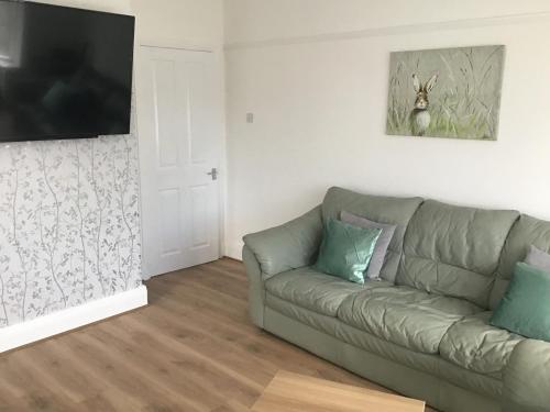 ein Wohnzimmer mit Couch und Flachbildfernseher in der Unterkunft 3 bed bungalow Penrhyn Bay Llandudno in Llandrillo-yn-Rhôs