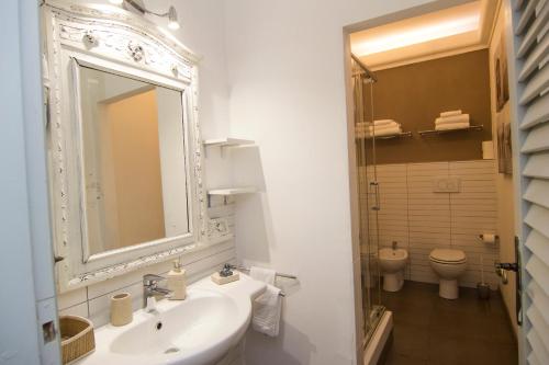 a bathroom with a sink and a mirror and a toilet at B&B 7 Rooms in Pisa