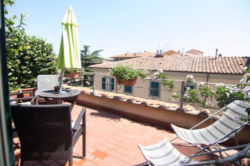 a patio with chairs and a table and an umbrella at B&B 7 Rooms in Pisa