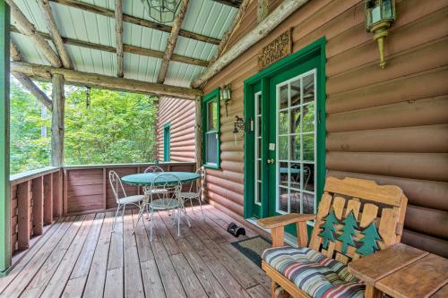 a wooden porch with a table and chairs on it at Spacious Mtn Cabin on 7 Private Acres in Athol! in Athol