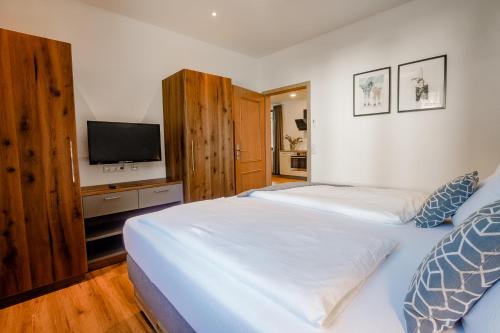 a bedroom with two beds and a flat screen tv at Der Lärchenhof Ferienwohnungen in Schönau am Königssee