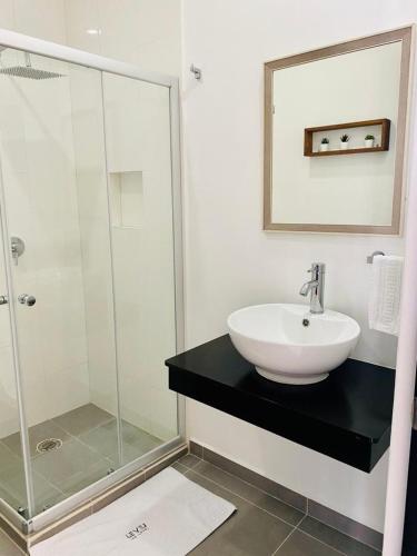 a bathroom with a sink and a glass shower at Apartamento Cleo in Cancún