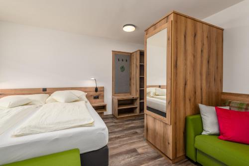 a bedroom with a bed and a green couch at Landgasthof Bierfriedl in Pruggern