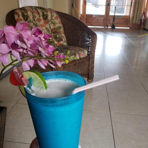a drink in a blue cup with a lime and a straw at Center Hotel in Imbé