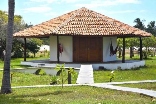 a small house with a thatched roof at Pousada Velho Bateau in Atins
