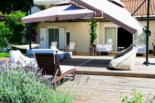 a patio with a table and chairs and an umbrella at Serenity Luxury Villa, Skiathos in Agia Paraskevi