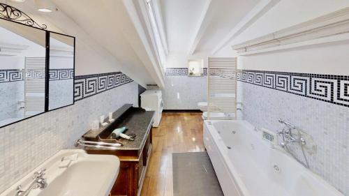 ein großes Badezimmer mit zwei Waschbecken und einer Badewanne in der Unterkunft Appartamento San Michele in Triest