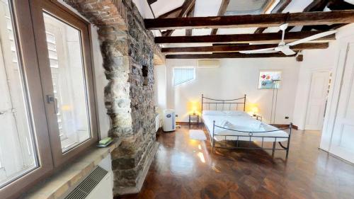 ein Schlafzimmer mit einem Bett und einer Ziegelwand in der Unterkunft Appartamento San Michele in Triest