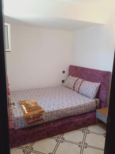 Un dormitorio con una cama con una mesa. en bungalow de charme en El Harhoura