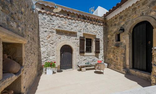 a stone building with a door and flowers in a courtyard at Meronas Eco House in Méronas