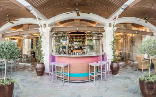a restaurant with a bar with purple stools at Columbia Beach Resort in Pissouri