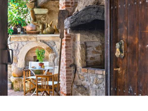 a stone oven with a table and chairs in a room at Meronas Eco House in Méronas
