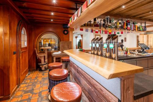 a bar in a kitchen with wooden walls and wooden stools at Landgasthof Bierfriedl in Pruggern