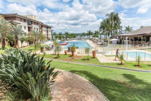 a person walking by a pool at a resort at Flat no Life Resort a Beira Lago in Brasilia