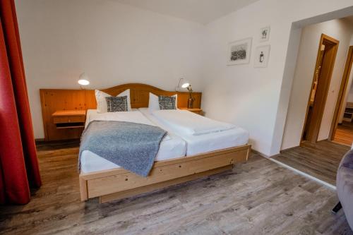 a bedroom with a large bed with a wooden headboard at Der Lärchenhof Ferienwohnungen in Schönau am Königssee