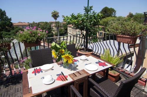 a table and chairs on a balcony with plants at B&B 7 Rooms in Pisa