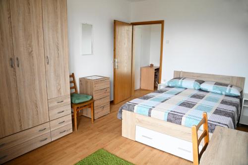 a bedroom with a bed and a desk and a chair at Apartma Čuk in Dutovlje