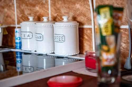 a shelf with four white containers on it at Iva Penthouse in Novi Sad