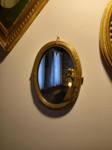 a gold mirror on a wall with a picture at Gioraldi Art Hotel in Ano Pedina