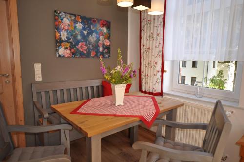 a dining room table with a vase of flowers on it at Wohlfühl-Ferienwohnungen König in Bad Elster