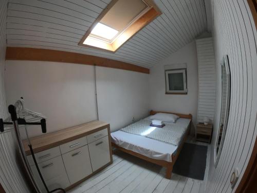 a small bedroom with a bed and a skylight at City Center House in Vodice