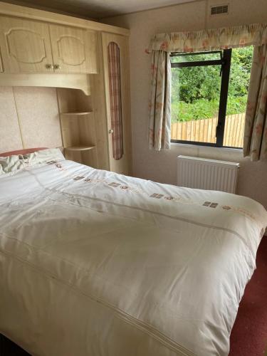 a large white bed in a bedroom with a window at Tummel 2 in Forfar