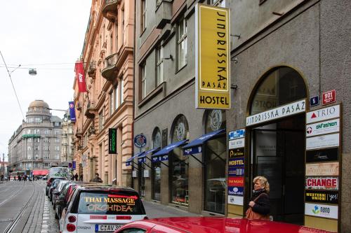 kobieta idąca ulicą miasta obok budynków w obiekcie A Plus Hostel - Centrum w Pradze