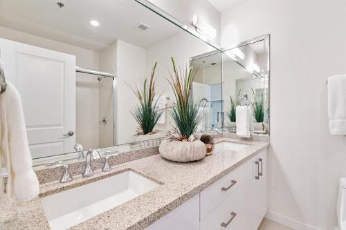 a bathroom with two sinks and a large mirror at Perfect big family getaway! Spectacular large balcony overlooking the pool Beachfront resort in South Padre Island
