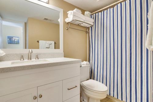 La salle de bains est pourvue de toilettes, d'un lavabo et d'un miroir. dans l'établissement Seascape 2305 Condo, à Galveston