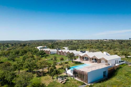 an aerial view of a house with a swimming pool at Sobreiras Alentejo Country Hotel - by Unlock Hotels in Santa Margarida da Serra