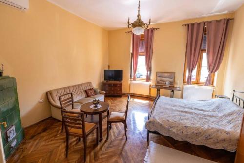 uma sala de estar com uma cama, um sofá e uma mesa em Apartman Gaudeamus em Varaždin