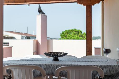 a dining room table with chairs and a glass of wine at Kosta's Apartments in Vonitsa