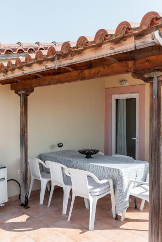 a table and white chairs in a room at Kosta's Apartments in Vonitsa