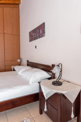 a bedroom with two beds and a desk with a lamp at Kosta's Apartments in Vonitsa
