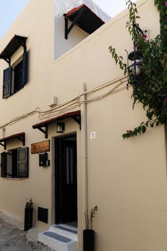 a white building with a black door and stairs at Naria Medieval House in Rhodes Town