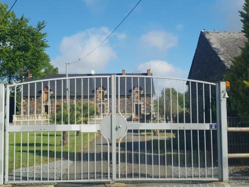 a white gate in front of a house at La halte de la vilaine in Sainte-Anne-sur-Vilaine