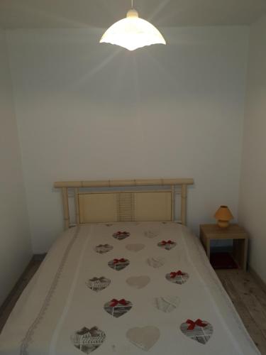 sypialnia z łóżkiem z narzutą z sercem w obiekcie La halte de la vilaine w mieście Sainte-Anne-sur-Vilaine
