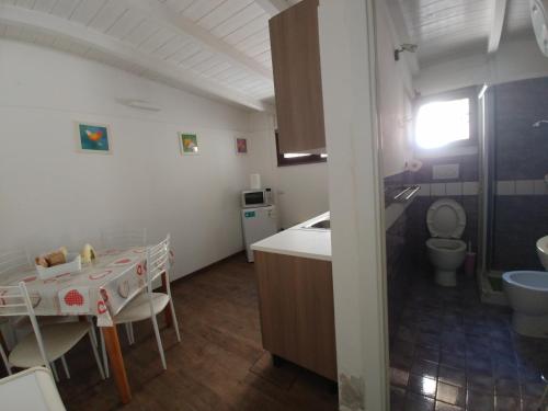 kuchnia ze stołem, zlewem i toaletą w obiekcie Asso Di Coppa w mieście Scafati