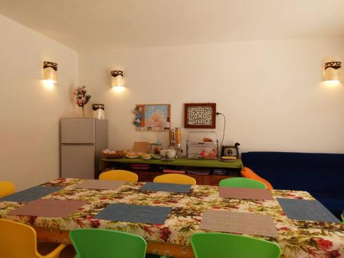 Habitación con mesa con sillas y nevera. en Lu Lisandru en Abbiadori