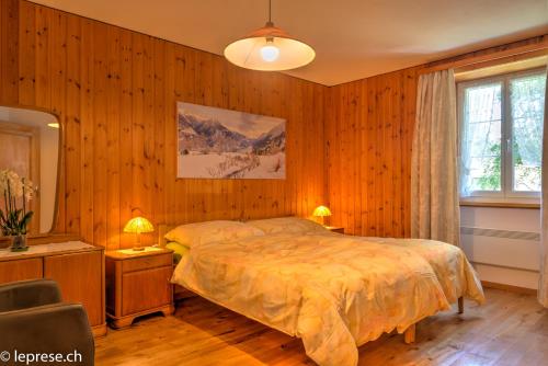 a bedroom with a bed and a desk and a chair at Casa Zanetti in Poschiavo