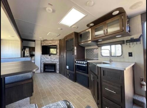 a kitchen in an rv with wooden cabinets and counters at 2020 Camper fully hooked-up at St. George RV Park! in St. George