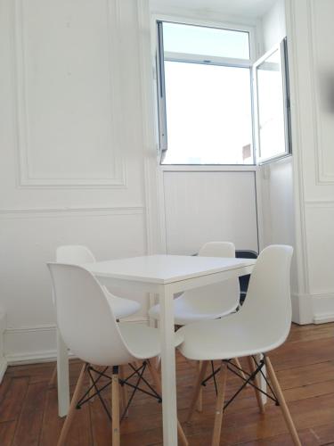 a white table and chairs in a room with a window at Baixa Terrace Hostel in Faro
