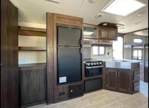a kitchen with a refrigerator and a stove top oven at 2020 Camper fully hooked-up at St. George RV Park! in St. George
