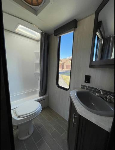 a small bathroom with a toilet and a sink at 2020 Camper fully hooked-up at St. George RV Park! in St. George