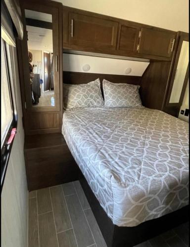 um quarto com uma cama e um espelho grande em 2020 Camper fully hooked-up at St. George RV Park! em St. George