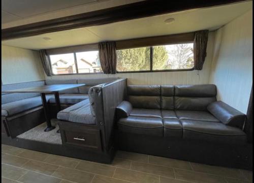 a living room with a couch and a table at 2020 Camper fully hooked-up at St. George RV Park! in St. George